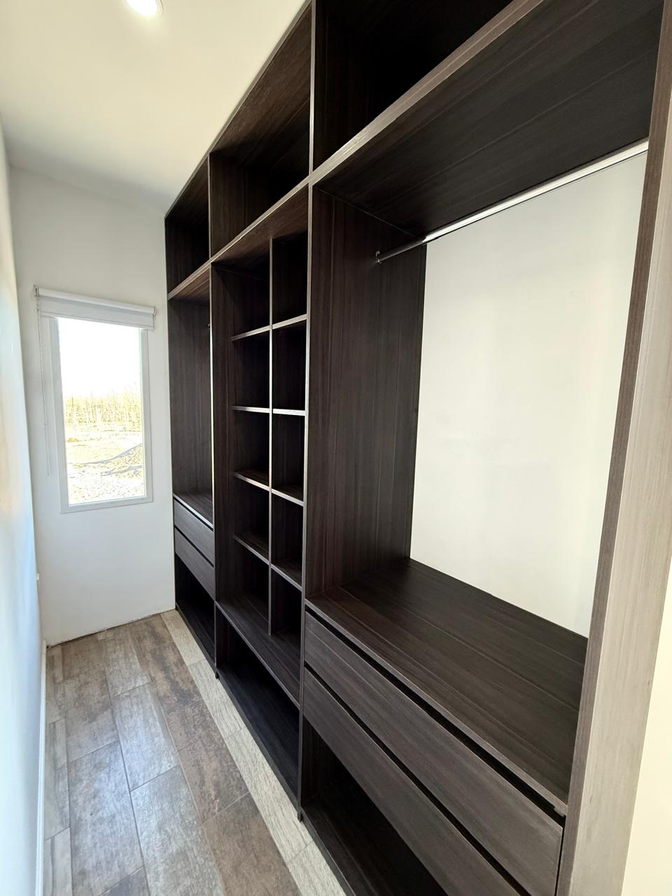 Vestidor a medida en madera oscura con cajoneras, estantes y barrales